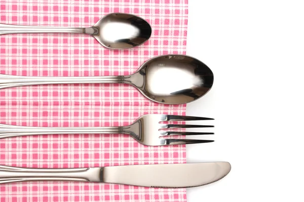 Forchetta, cucchiaio e coltello in un panno a quadri con un fiocco isolato su bianco — Foto Stock