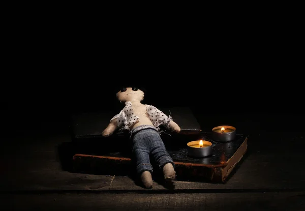 Voodoo doll boy on a wooden table in the candlelight — Stock Photo, Image