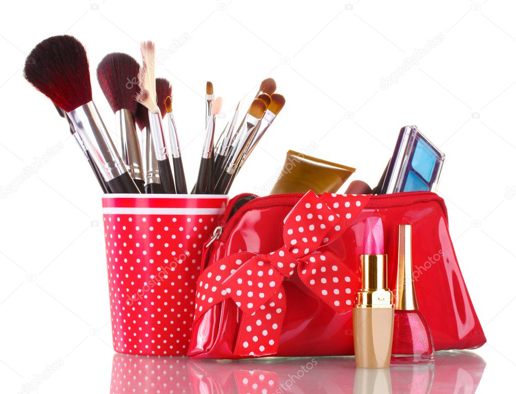 Red glass with brushes and makeup bag with cosmetics isolated on white