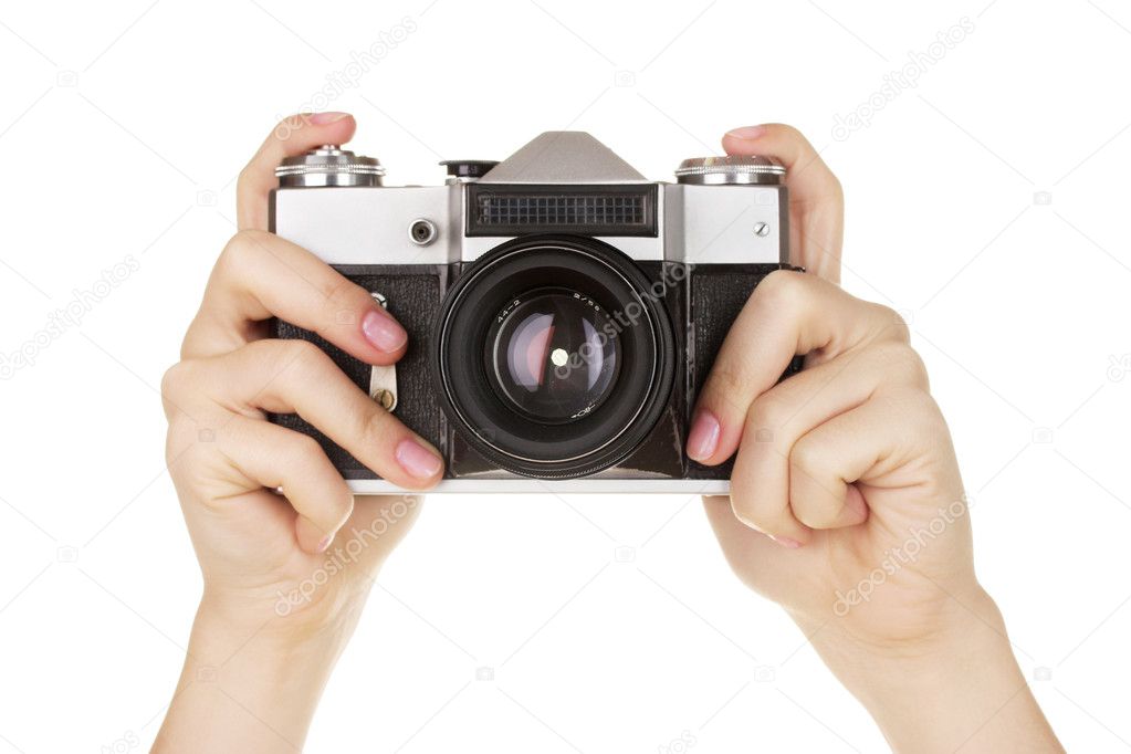 Old photo camera in hands isolated on white