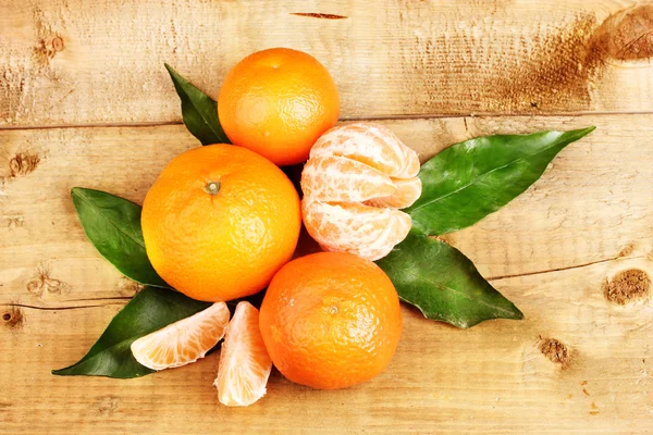 Mandarinas con hojas sobre mesa de madera —  Fotos de Stock