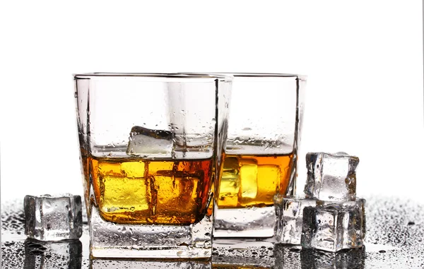 Iki bardak scotch viski ve buz üzerinde beyaz izole tablo — Stok fotoğraf
