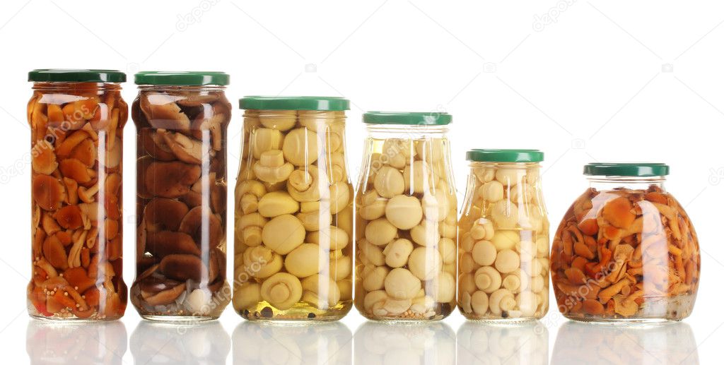 Different glass jars of marinated mushrooms isolated on white