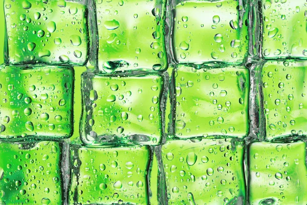 Smeltende ijsblokjes op groene close-up — Stockfoto