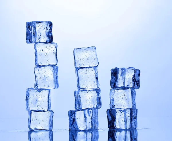 Topienie kostek lodu na niebieskim tle — Zdjęcie stockowe