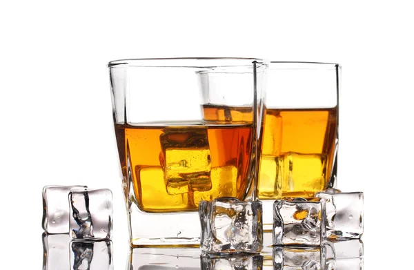 Två glas av skotsk whisky och is på bordet isolerad på vit — Stockfoto
