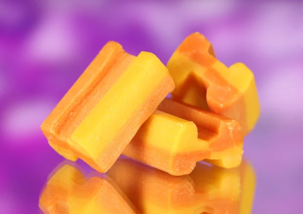 Smakelijke kauwgom op paarse achtergrond — Stockfoto