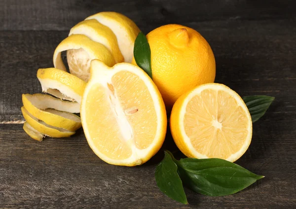 Стиглі лимони з листям на дерев'яному столі — стокове фото