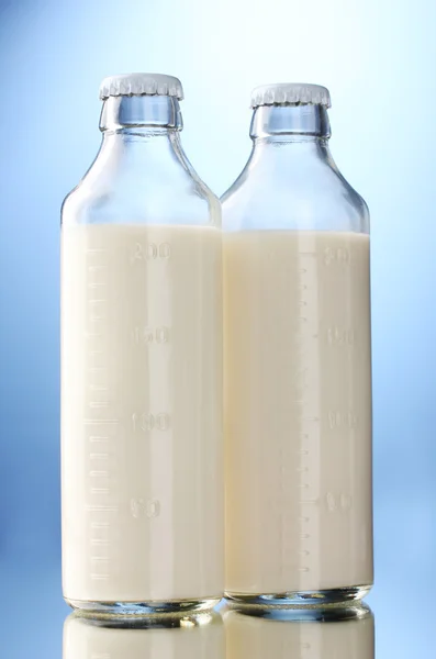 Bottiglie di latte su fondo blu — Foto Stock