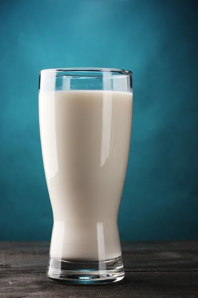 Glas melk op houten tafel op blauwe achtergrond — Stockfoto