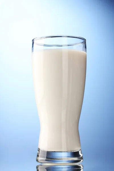 Mavi arka planda bir bardak süt. — Stok fotoğraf