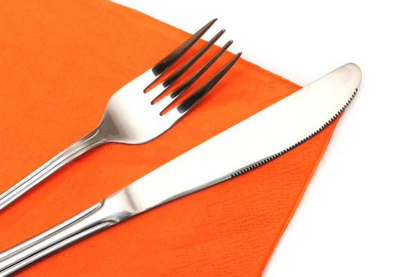 Vork en mes in een oranje doek geïsoleerd op wit — Stockfoto
