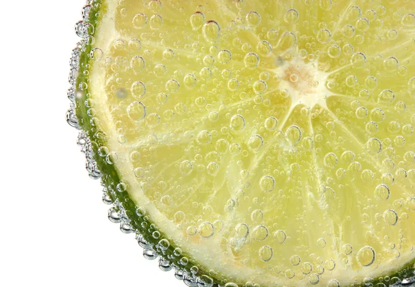 Slice of lime in the water with bubbles — Stock Photo, Image