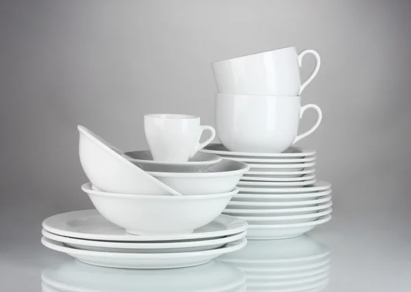 Prázdné misky, talíře a poháry na šedém pozadí — Stock fotografie