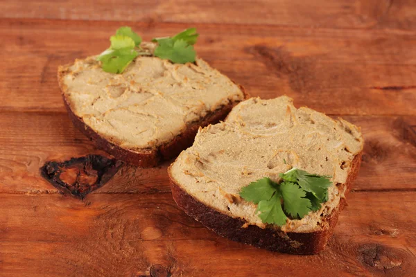 Fresh pate on bread on wooden table — Stock Photo, Image