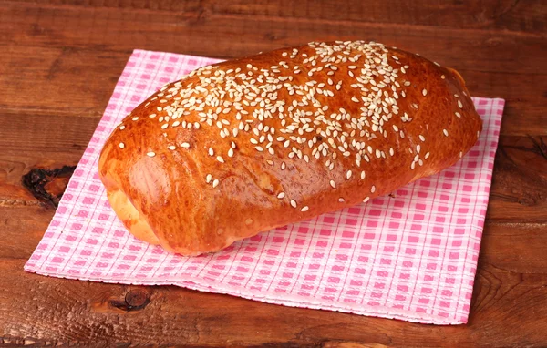 Um pão de rolo em guardanapo na mesa de madeira — Fotografia de Stock