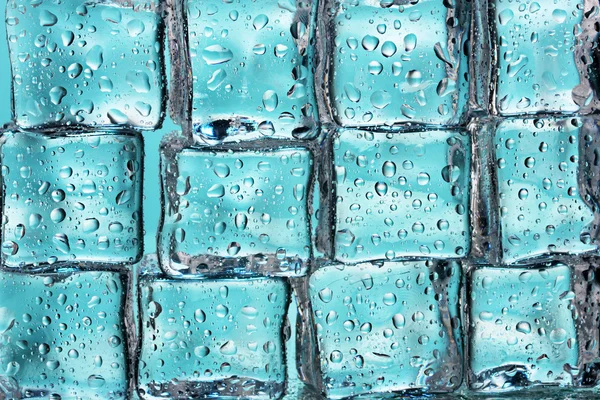 Таяние кубиков льда на голубом макро — стоковое фото