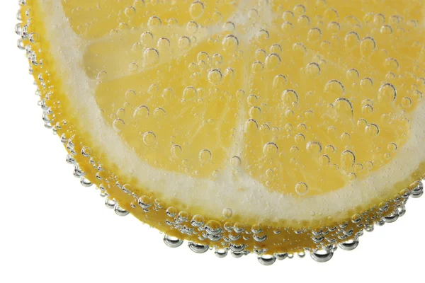 Кусок лимона в воде с пузырьками — стоковое фото