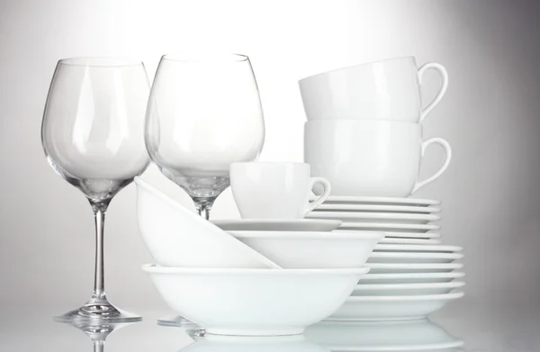 Leere Schalen, Teller, Tassen und Gläser auf grauem Hintergrund — Stockfoto