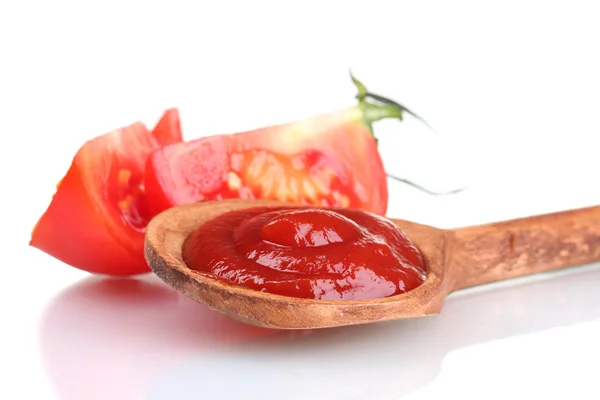Ketchup saboroso em colher de madeira e tomate isolado em branco — Fotografia de Stock