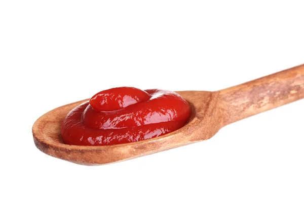 Tasty ketchup in wooden spoon isolated on white — Stock Photo, Image