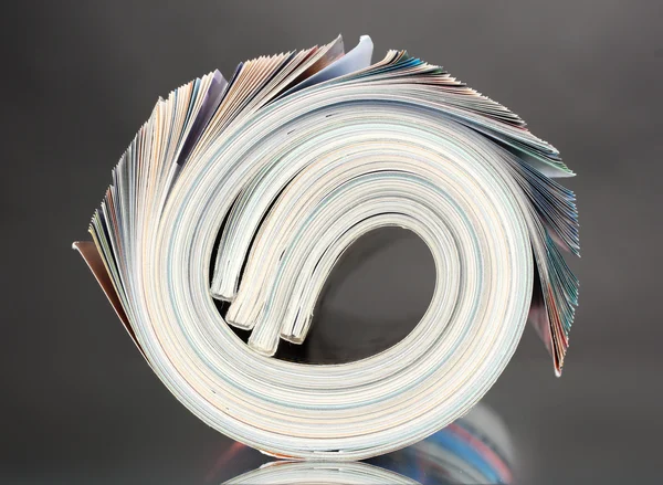 stock image Rolled up magazines on gray background