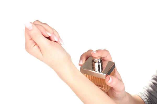 Manos de las mujeres y frasco de perfume aislado en blanco — Foto de Stock