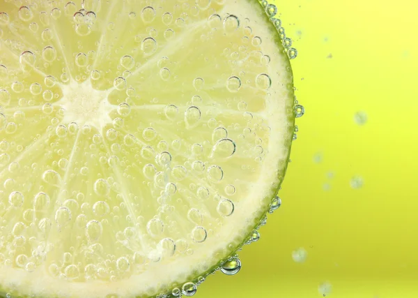 Slice of lemon in the water with bubbles — Stock Photo, Image