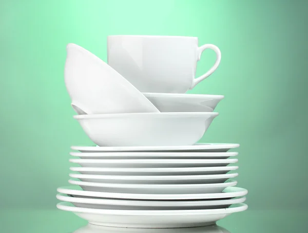 Καθαρά πιάτα και κύπελλο σε πράσινο φόντο — Φωτογραφία Αρχείου