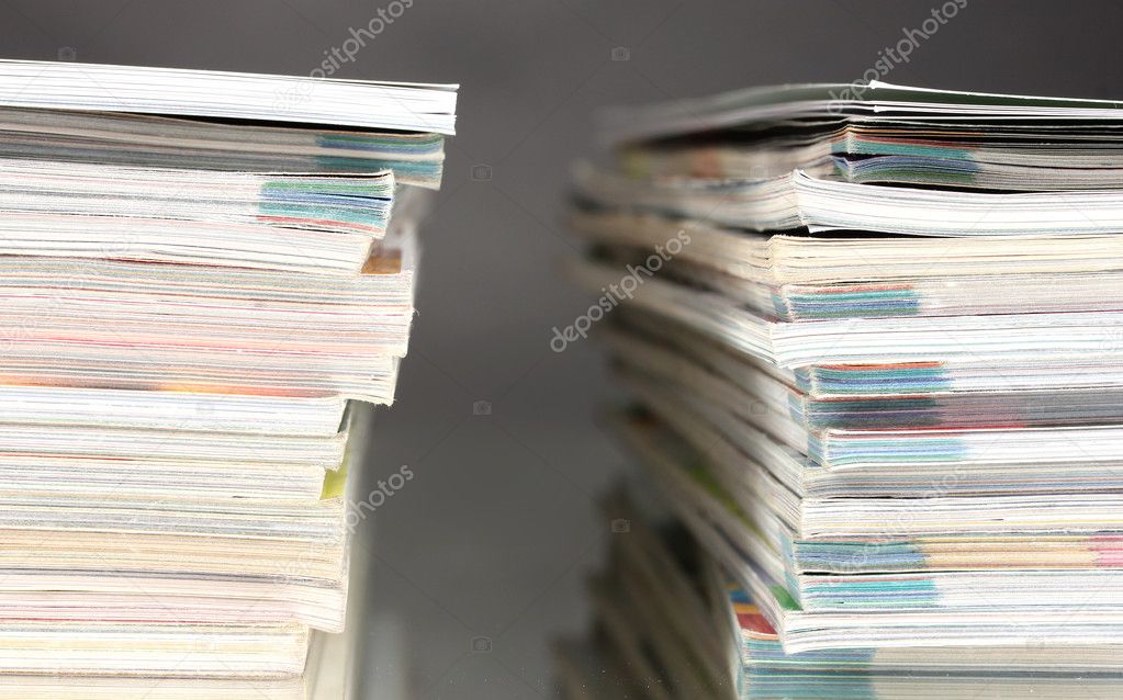 Stacks of magazines on gray background