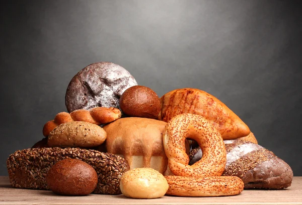 Delizioso pane su tavolo di legno su sfondo grigio — Foto Stock