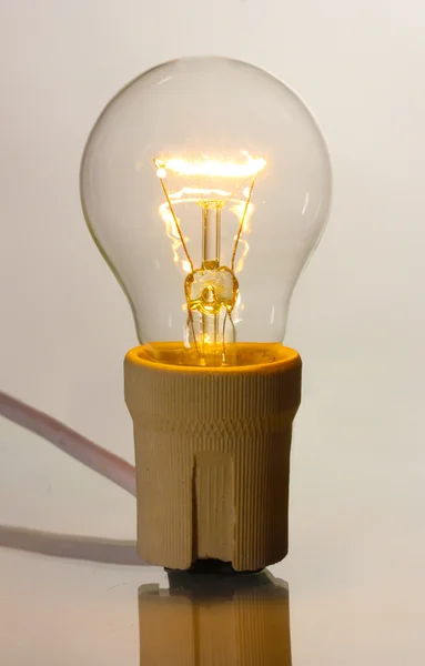 A lit light bulb isolated on white — Stok fotoğraf