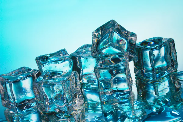 Mavi arka plan üzerinde eriyen buz küpleri — Stok fotoğraf