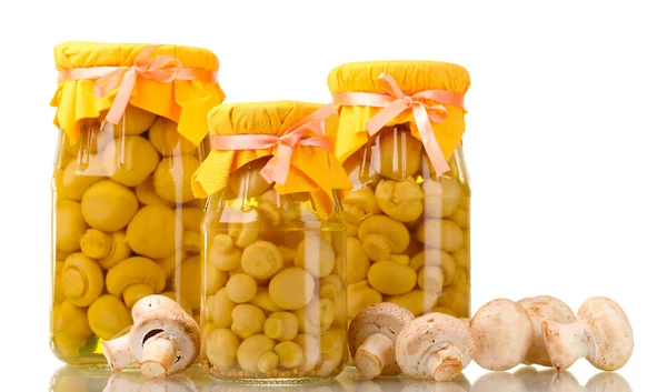 Deliciosos cogumelos marinados nos frascos de vidro e champinhons crus isolados — Fotografia de Stock