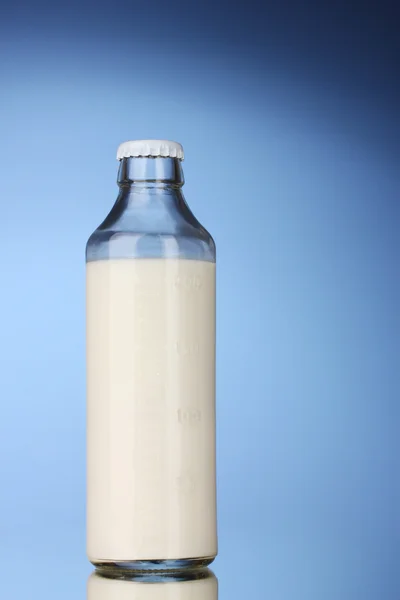 Garrafa de leite no fundo azul — Fotografia de Stock