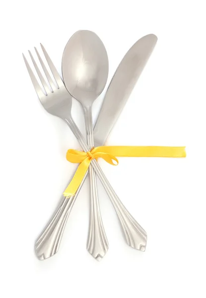 Ασημί πιρούνι και κουτάλι, μαχαίρι δεμένα με μια κορδέλα κίτρινο που απομονώνονται σε λευκό — Φωτογραφία Αρχείου