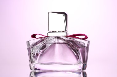 Women's perfume in beautiful bottle on pink background clipart