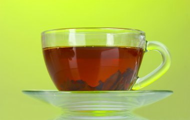 Black tea in glass cup on green background clipart