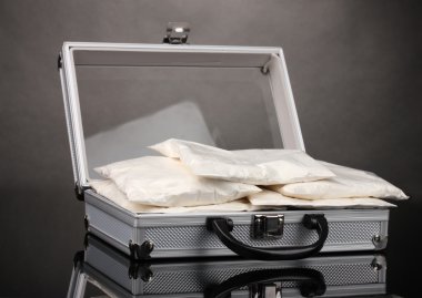 Сocaine in a suitcase on grey background clipart