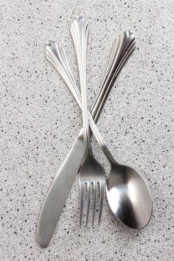 Fork, spoon and knife on marble table clipart