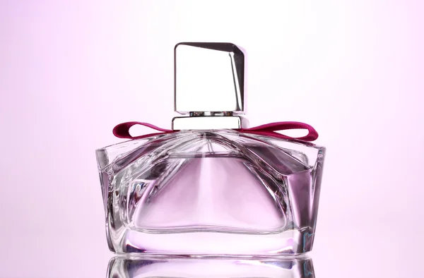 Жіночі парфуми в красивій пляшці на рожевому фоні — стокове фото
