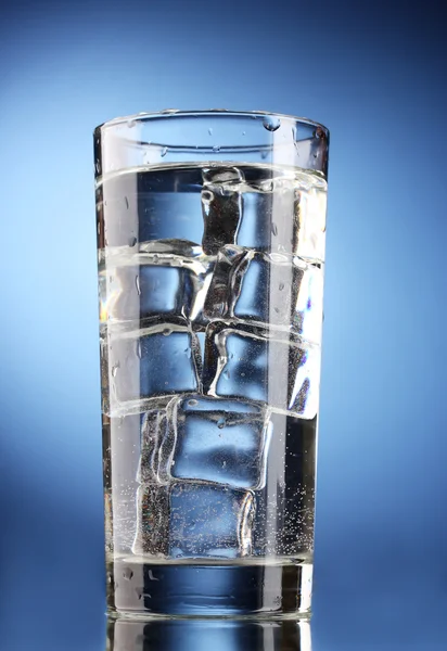 Bicchiere d'acqua con ghiaccio su fondo blu — Foto Stock