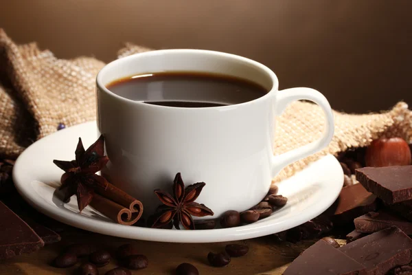 コーヒー カップと豆、シナモンスティック、ナットおよびチョコレート木製テーブル o — ストック写真