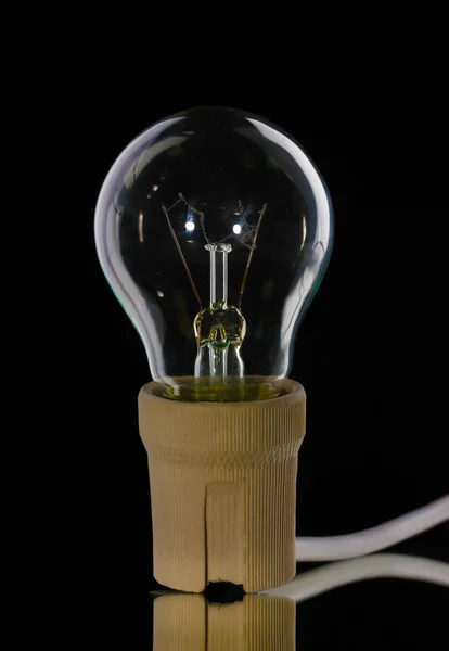 Light bulb in cartridge on black background — Stock Photo, Image