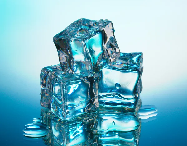 Derretendo cubos de gelo no fundo azul — Fotografia de Stock