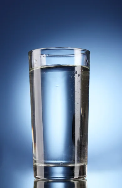 파란색 배경에 있는 물 한 컵 — 스톡 사진