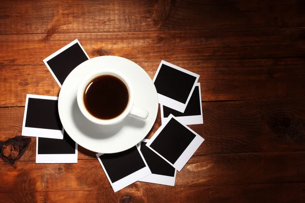 Papéis fotográficos com café sobre fundo de madeira — Fotografia de Stock