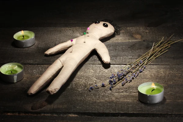 Voodoo-docka pojke på ett träbord i levande ljus — Stockfoto