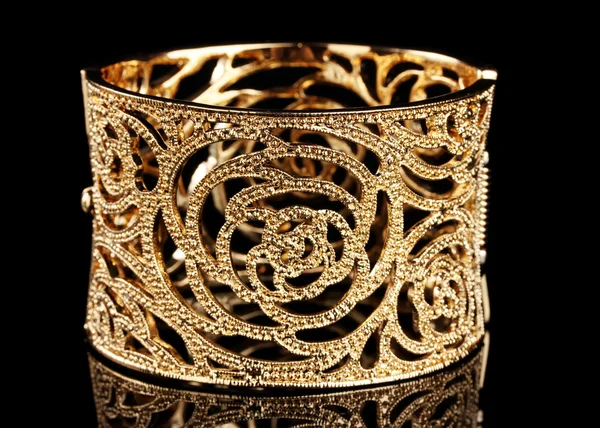 Hermosa pulsera de oro sobre fondo negro —  Fotos de Stock