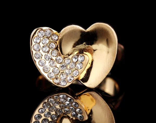 Hermoso anillo de oro con piedras preciosas sobre fondo negro — Foto de Stock